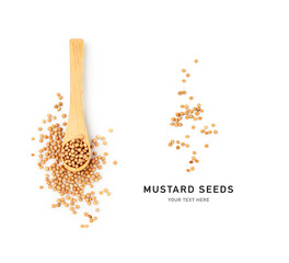 Yellow mustard seeds in wooden spoon isolated on white.