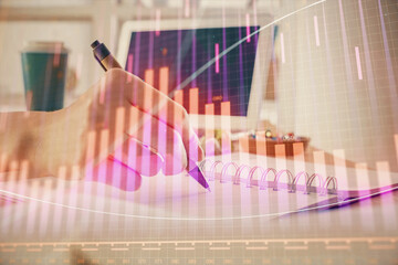 Financial forex graph drawn over hands taking notes background. Concept of research. Multi exposure