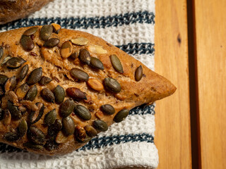 Dark buns on a wooden background. Bakery products with grains.
