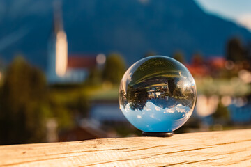 Crystal ball alpine landscape shot with a church near Hirschegg, Kleinwalsertal valley, Vorarlberg, Austria