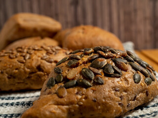 Dark buns on a wooden background. Bakery products with grains.