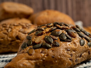 Dark buns on a wooden background. Bakery products with grains.