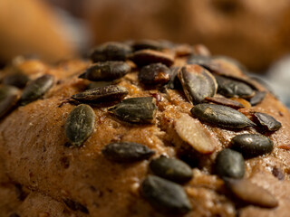 Dark buns on a wooden background. Bakery products with grains.