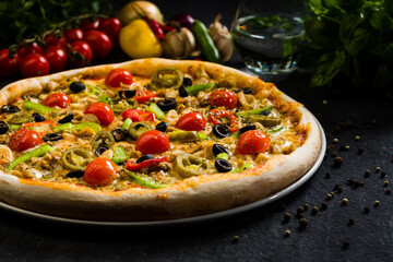 Spicy chicken pizza with olives cherry tomatoes, peppers and jalapenos