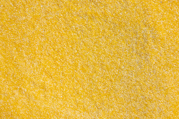 Fototapeta premium Polenta or corn flour background. Texture of polenta, yellow cornmeal flour, semolina, fast cooking closeup of grains.