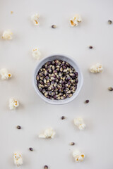 Blue popcorn kernels in white bowl with white background, healthy snack, popcorn kernels, healthy eating