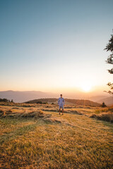 Man in shirt watching sunset on a mountain in Beskydy mountains, Czech republic. Soaking up positive energy and relieving stress. Feeling yourself