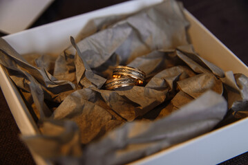 wedding rings on kraft paper with golden light