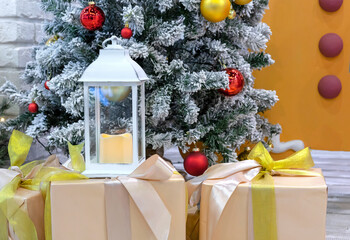 White Christmas lantern with a candle on the boxes with Christmas gifts.