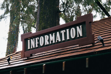 "Information" Vintage wooden signboard in top of a roof.