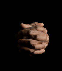 man praying to god with hands together Caribbean man praying on white background with people stock photo