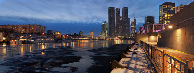Panorama of frozen Moskva river and Moscow business center skyscrapers at nightfall