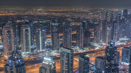 Fototapeta na wymiar JLT skyscrapers and Dubai marina near Sheikh Zayed Road aerial all night timelapse. Residential buildings