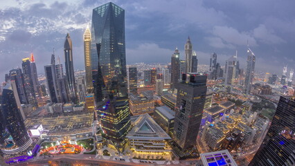 Panorama of futuristic skyscrapers after sunset in financial district business center in Dubai day to night timelapse