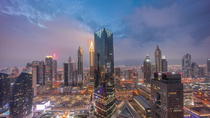 Panorama of futuristic skyscrapers after sunset in financial district business center in Dubai day to night timelapse