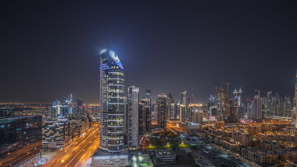 Obraz na płótnie Canvas Panorama showing Dubai's business bay towers aerial night timelapse. Rooftop view of some skyscrapers
