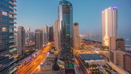 Panoramic view of the Dubai Marina and JBR area and the famous Ferris Wheel aerial night to day timelapse