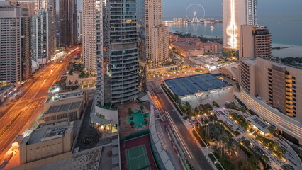 Panoramic view of the Dubai Marina and JBR area and the famous Ferris Wheel aerial night to day timelapse