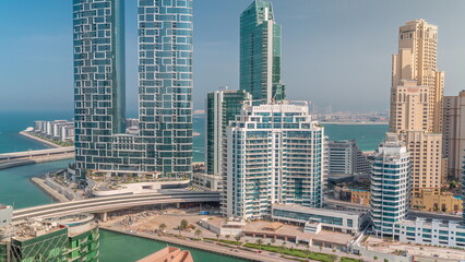 Fototapeta premium Promenade and canal seen from Dubai marina timelapse. Aerial view to JBR district and Bluewaters Island behind