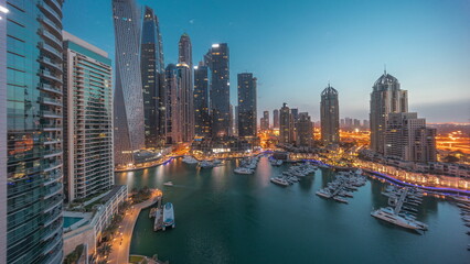 Fototapeta premium Dubai marina tallest skyscrapers and yachts in harbor aerial night to day timelapse.