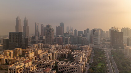 Fototapeta na wymiar Skyscrapers in Barsha Heights district and low rise buildings in Greens district aerial timelapse. Dubai skyline