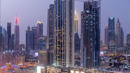 Obraz premium Row of the tall buildings around Sheikh Zayed Road and DIFC district aerial day to night timelapse in Dubai