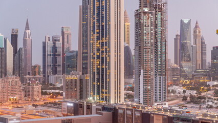 Panorama of the tall buildings around Sheikh Zayed Road and DIFC district aerial night to day timelapse in Dubai
