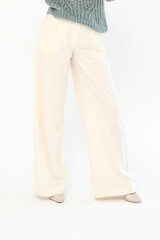 Cropped view of stylish woman in light trousers isolated on white background. Vertical photo