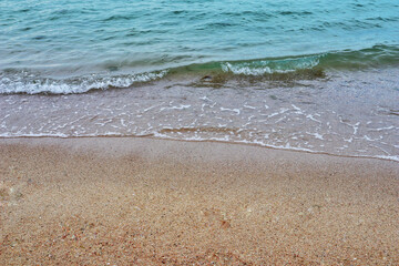 Sea coast and moving wave at the sandy beach for background and inspirational text.