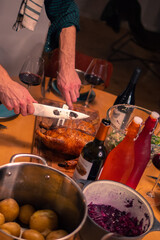 Man cutting into a roasted duck with a knife for a dinner party in Denmark