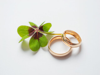 Wedding rings and a four leaf clover on a white background. Declaration of love, wedding day,...