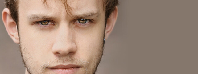 Fototapeta premium concentrated handsome young man with brown eyes, beard and healthy skin looking to camera. High quality photo