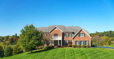 Fototapeta na wymiar Large brick house with a large green lawn.