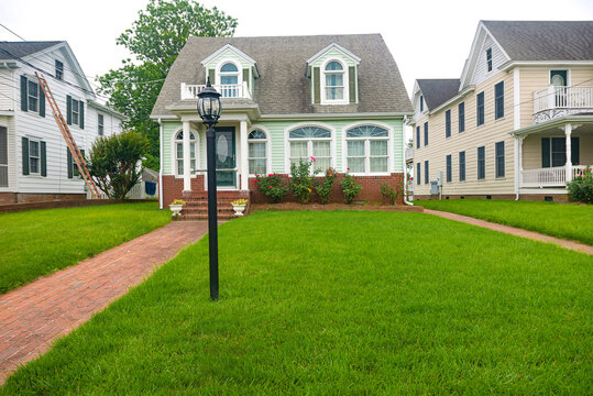 Classic American House With A Brick Sidewalk Leading To The Front Door.