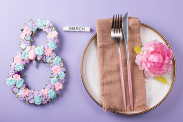 Festive table setting. The number 8 decorated with flowers on a white plate. Congratulations on the International Women's Day on March 8, a festive postcard banner