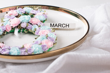 Festive table setting. The number 8 decorated with flowers on a white plate. Congratulations on the International Women's Day on March 8, a festive postcard banner