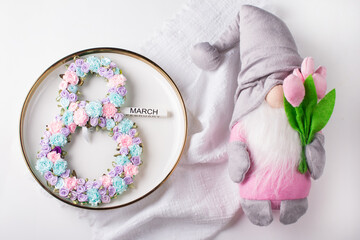 Festive table setting. The number 8 decorated with flowers on a white plate. Congratulations on the International Women's Day on March 8, a festive postcard banner