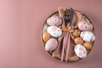 Easter table setting. Painted Easter eggs on a white plate, top view