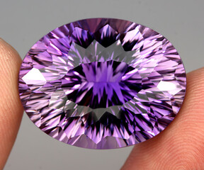 Natural gemstone purple amethyst on gray background