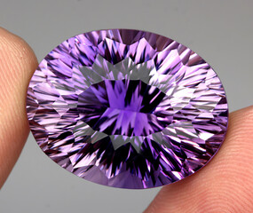 Natural gemstone purple amethyst on gray background