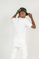 Back side of an african man wearing white blank shirt, doing a pose with both of his hand on his hat
