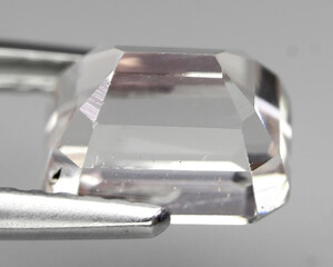 Natural beautiful gemstone kunzite on gray background