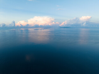 Sunrise illuminates clouds that drift over the calm waters of the Solomon Islands. This scenic...
