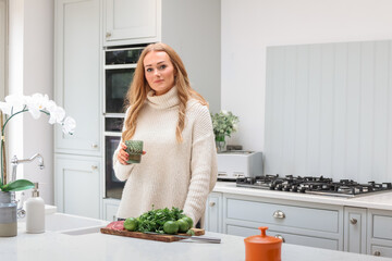 Young woman is preparing in the kitchen. Healthy Food. Salad. Diet. Dieting Concept. Healthy Lifestyle. Cooking At Home. Prepare Food. Cutting ingredients on the table