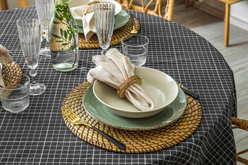 Beautiful table setting with napkins and glasses in stylish room