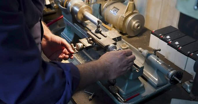 Watchmaker working with a antique lathe A man is working with a piece of metal with a lathe