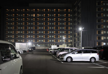Full parking lot by multi-story hotel building at night - 558780110