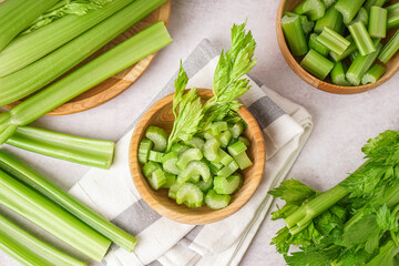 Wooden bowl with cut celery on table