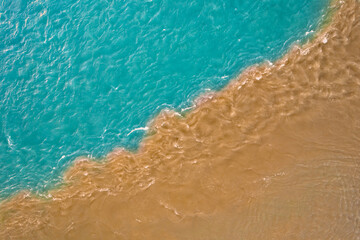 Water pollution by waste from factories and production. Confluence of clean blue river and dirty...