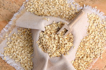 Napkin with raw oatmeal on color background